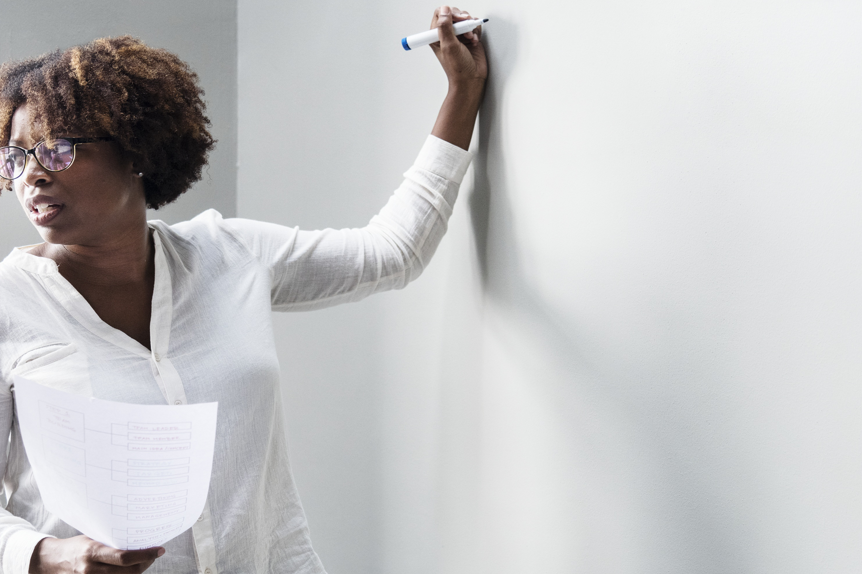 Intelesi - Brand Image of an African Teacher writing on whiteboard